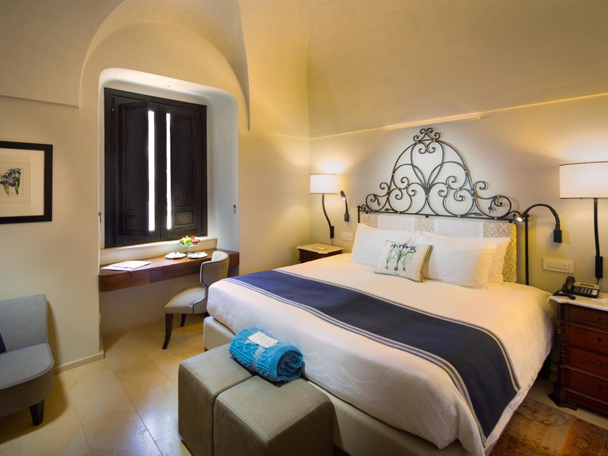 Double room with shutter windows and iron cast head board at Monastera Santa Rosa, luxury hotel in Italy