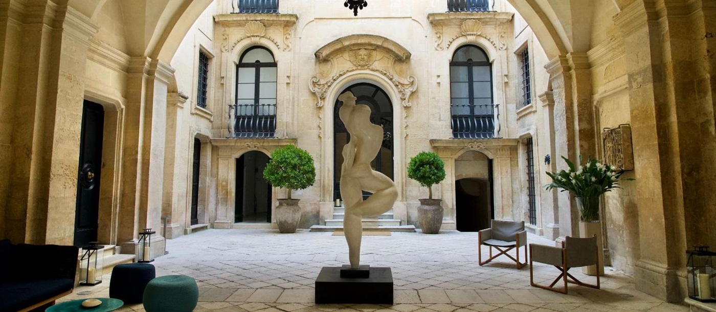 White marble sculpture in the courtyard of luxury hotel Palazzo Bozzi Corso in Lecce, Italy