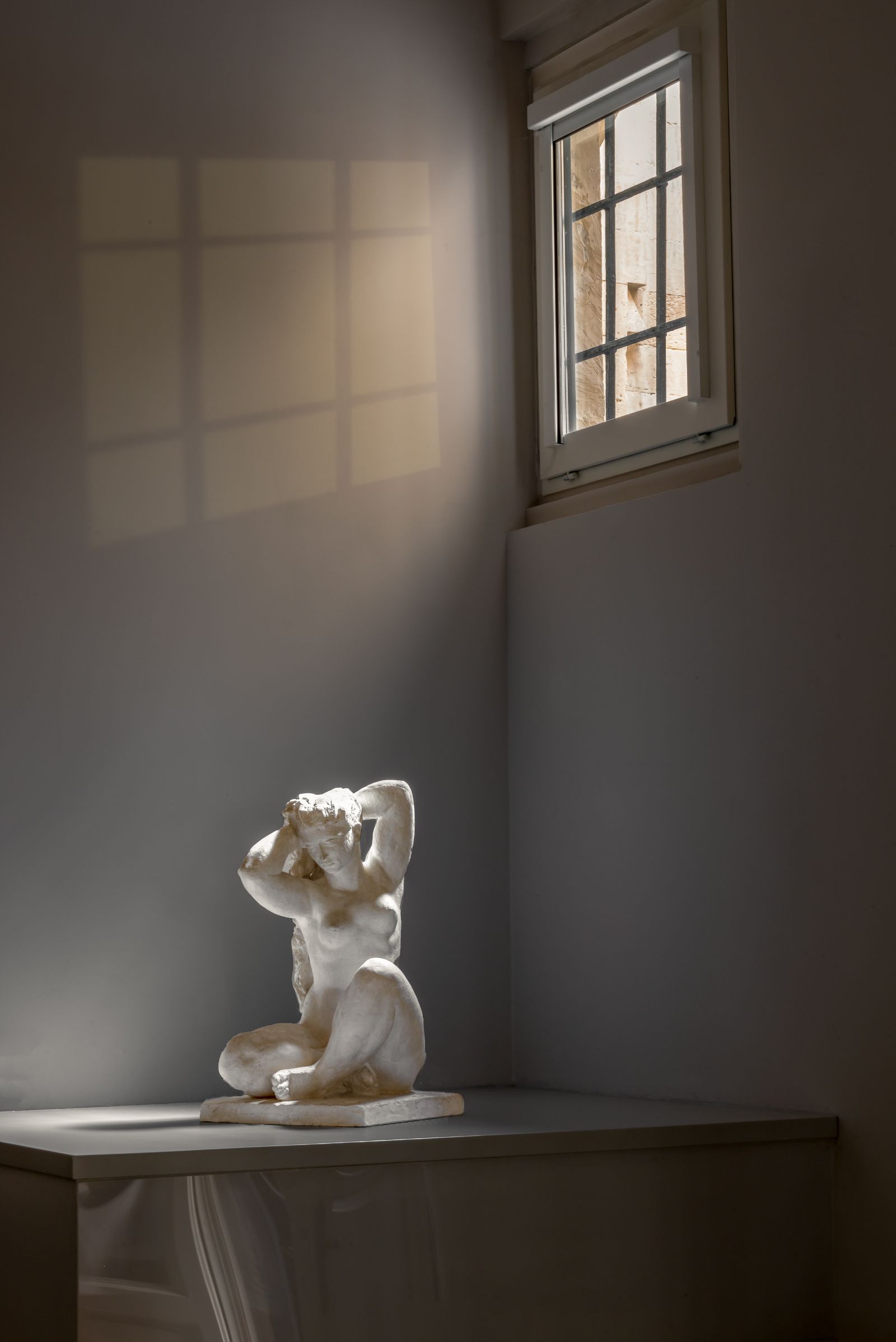 White marble sculpture of a woman underneath a window at luxury hotel Palazzo Bozzi Corso in Lecce, Italy