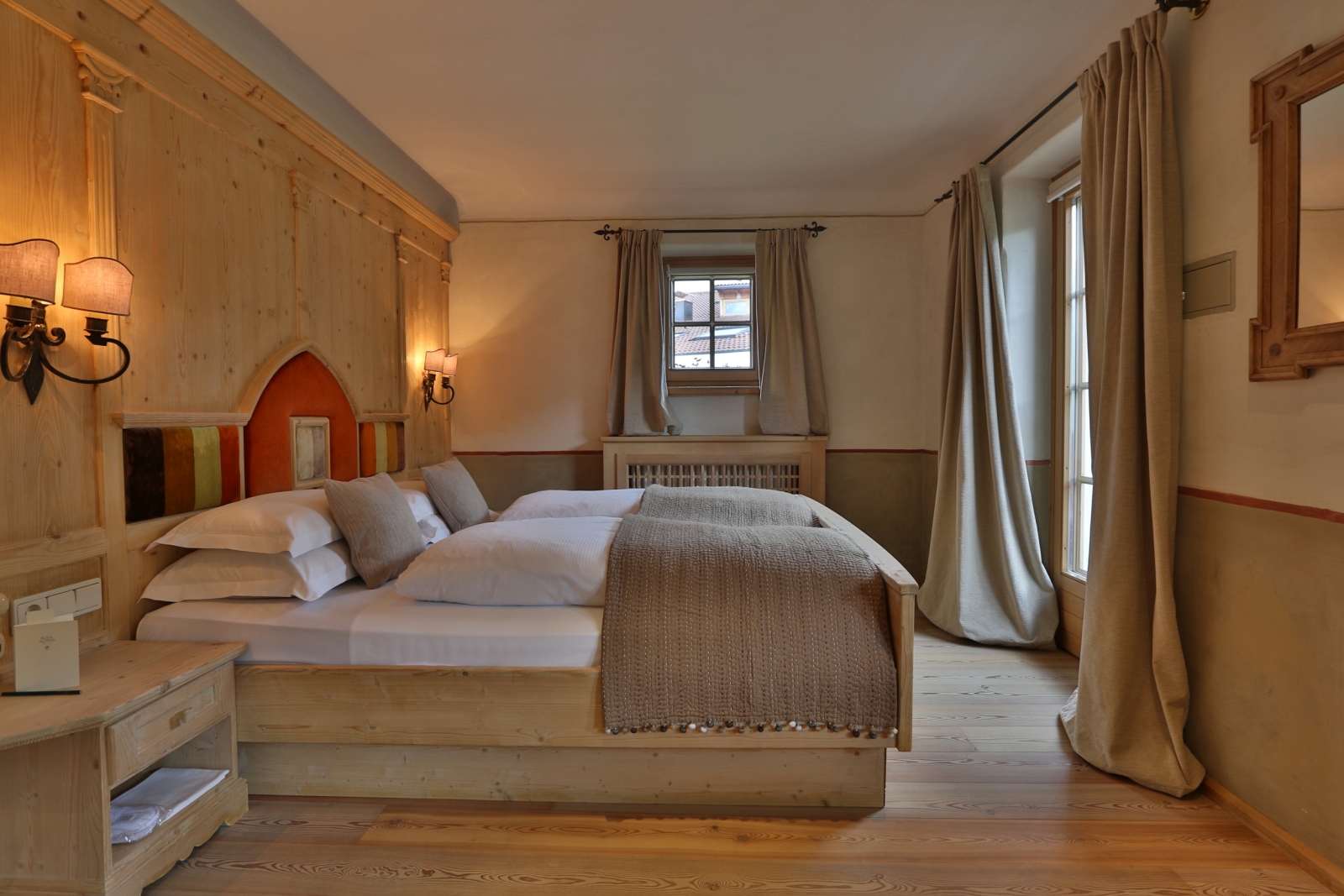 Deluxe room with wooden wall and features and a natural colour palette at luxury hotel Rosa Alpina in Italy