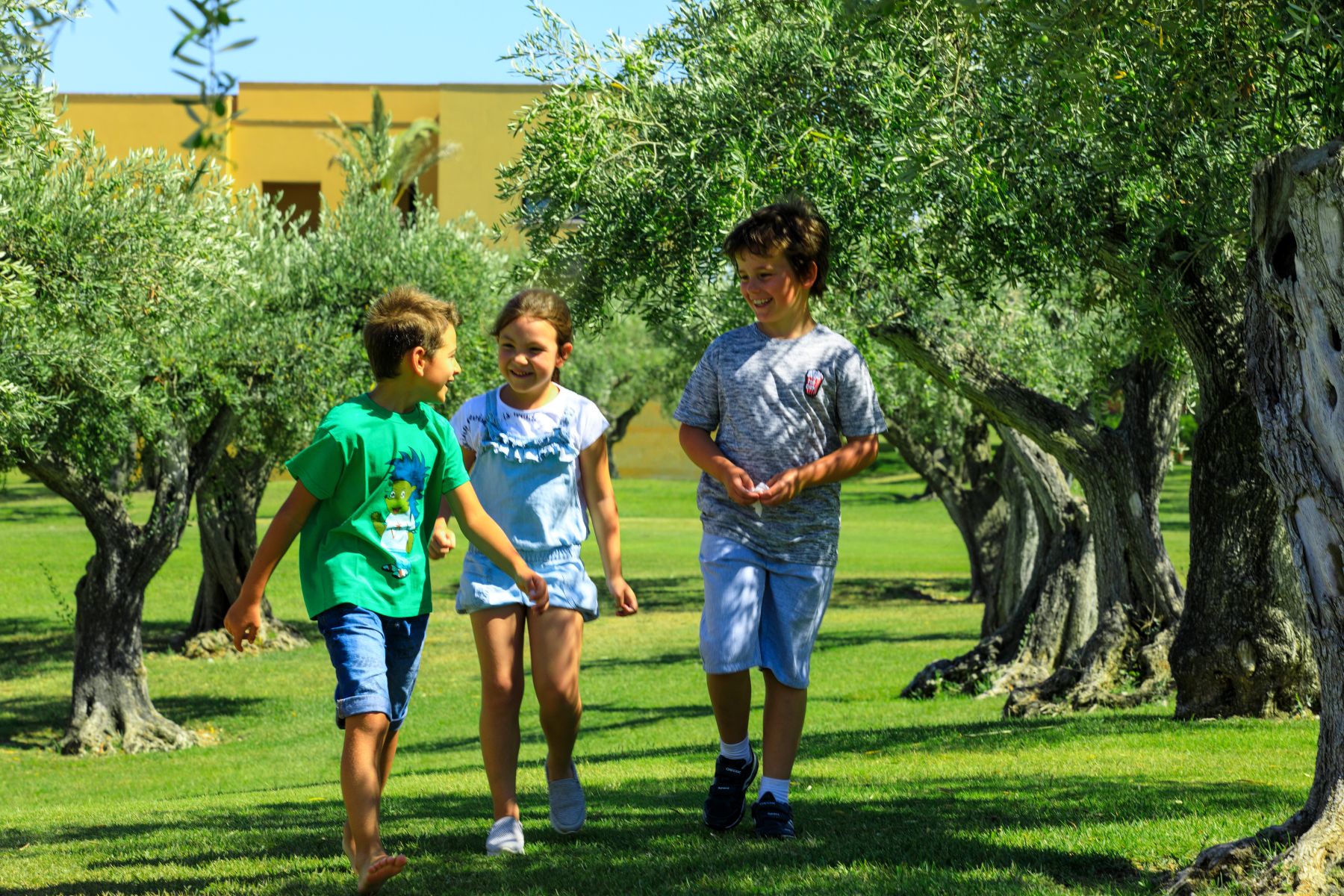 Children playing in an olive grove at the Rocco Forte Verdura Resort in Sicily