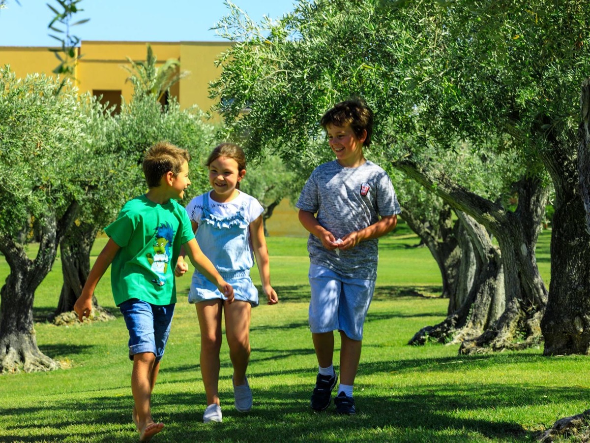 Children playing in an olive grove at the Rocco Forte Verdura Resort in Sicily