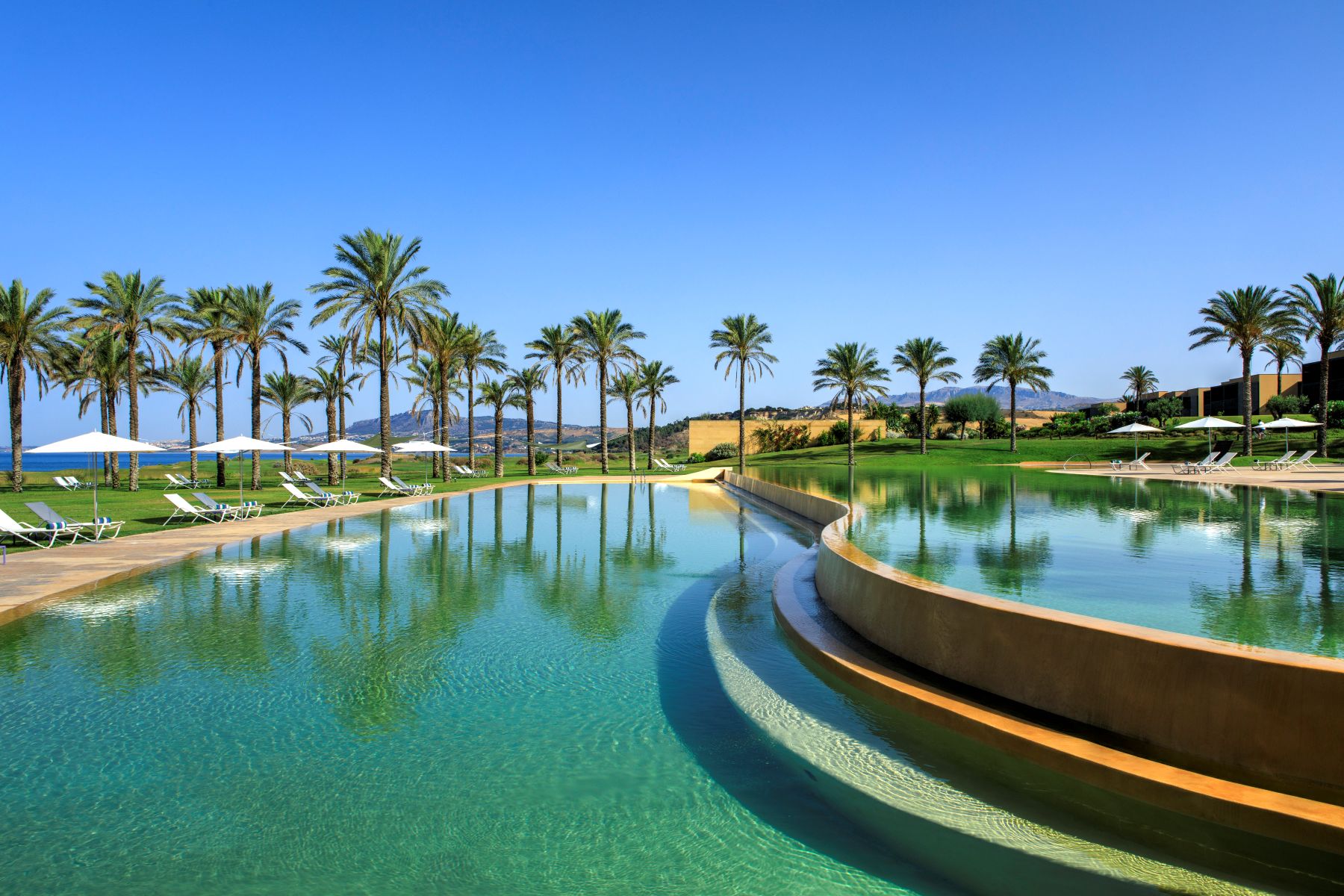 View across large swimming pool at Rocco Forte Verdura Resort in Sicily