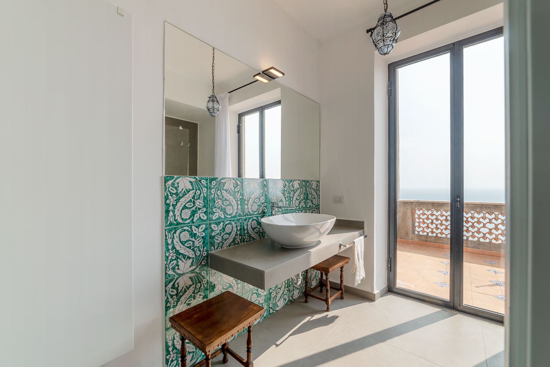 Bathroom with large glass doors opening onto the terrace at Castello Sul Mare in Amalfi