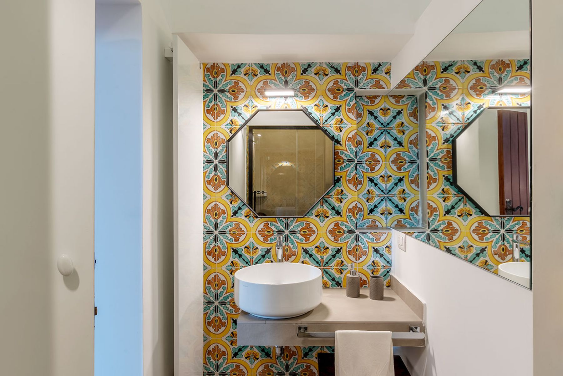 Bathroom with mosaic walls and a washbasin and mirror at Castello Sul Mare in Amalfi