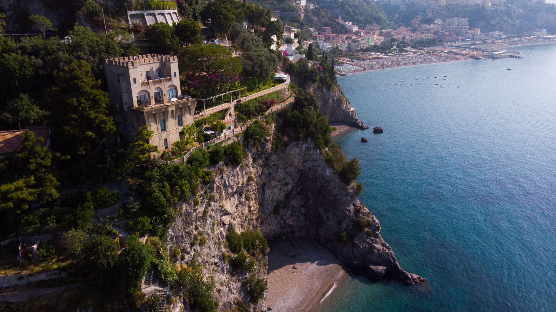 Drone view of the front of Castello Sul Mare with view of the tower building and the coast in Amalfi