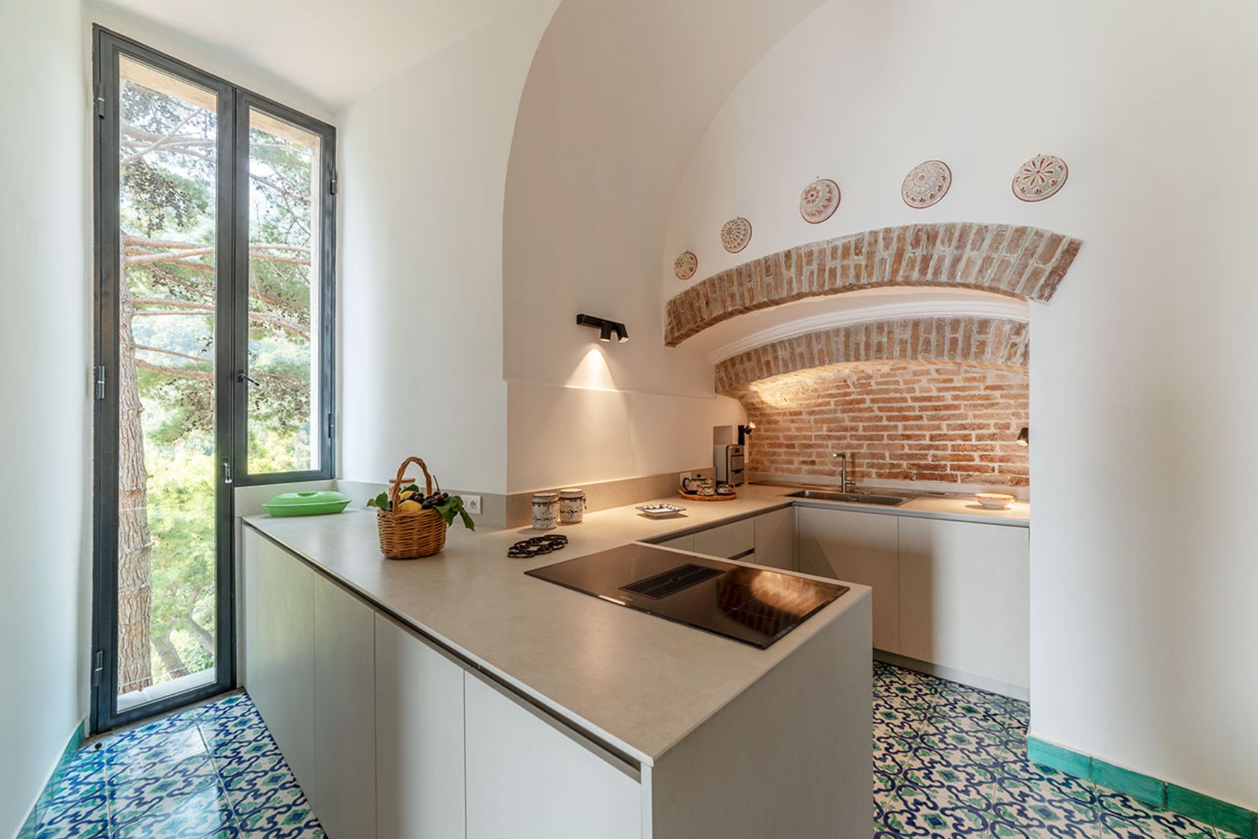 Modern kitchen with tiled floors and tall glass door at Castello Sul Mare in Amalfi