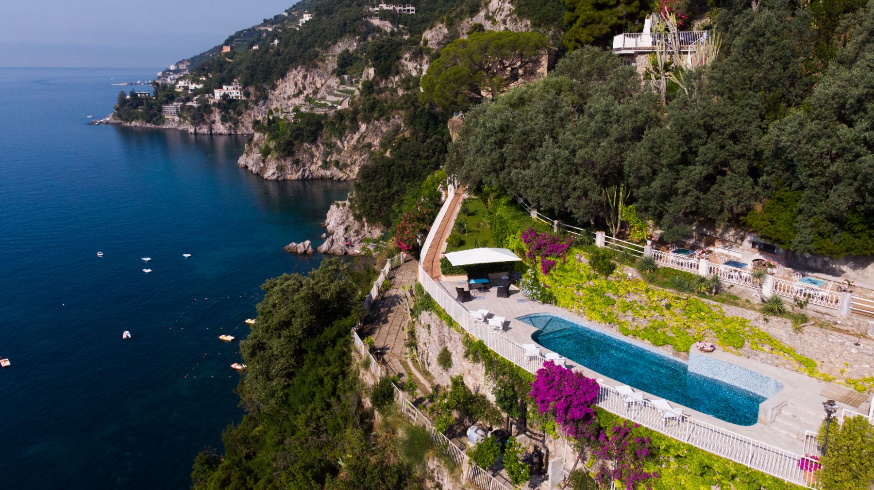 Drone view of the pool outdoor pool area at Castello Sul Mare at the edge of a cliff in Amalfi