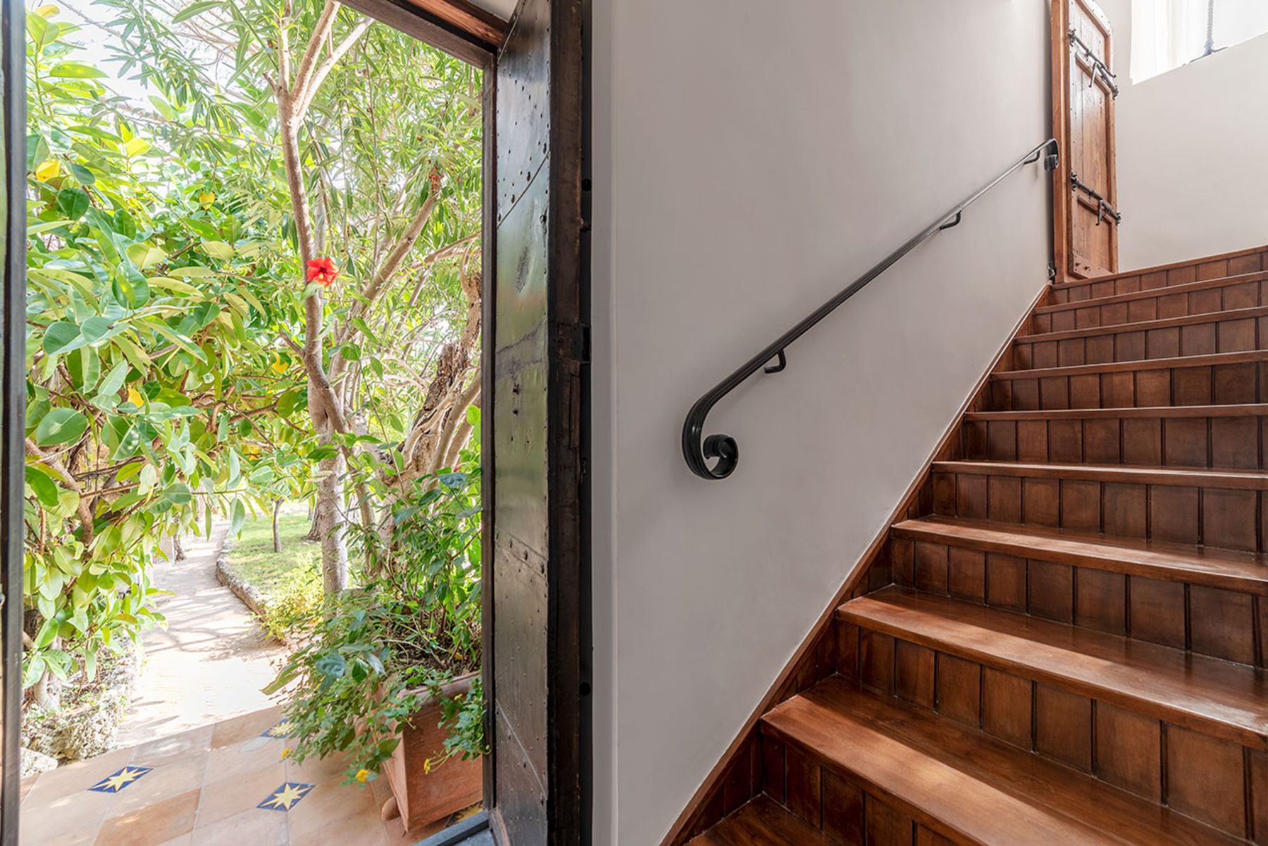 Indoor wooden stairs with view of the outdoor garden at Castello Sul Mare in Amalfi