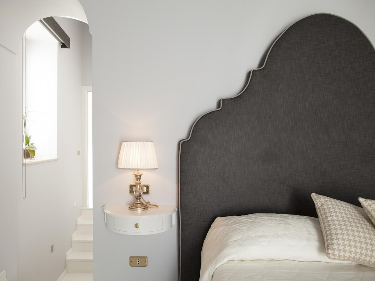 Bedroom with double bed, bedside table and lamp at Villa di Praiano on the Amalfi Coast in Italy