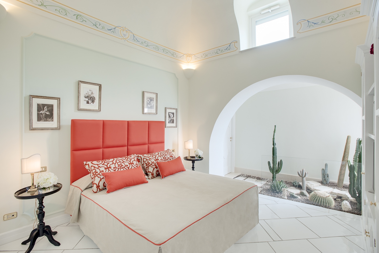 Bedroom with double bed, bedside tables, lamps, picture frames and cacti at Villa di Praiano on the Amalfi Coast in Italy