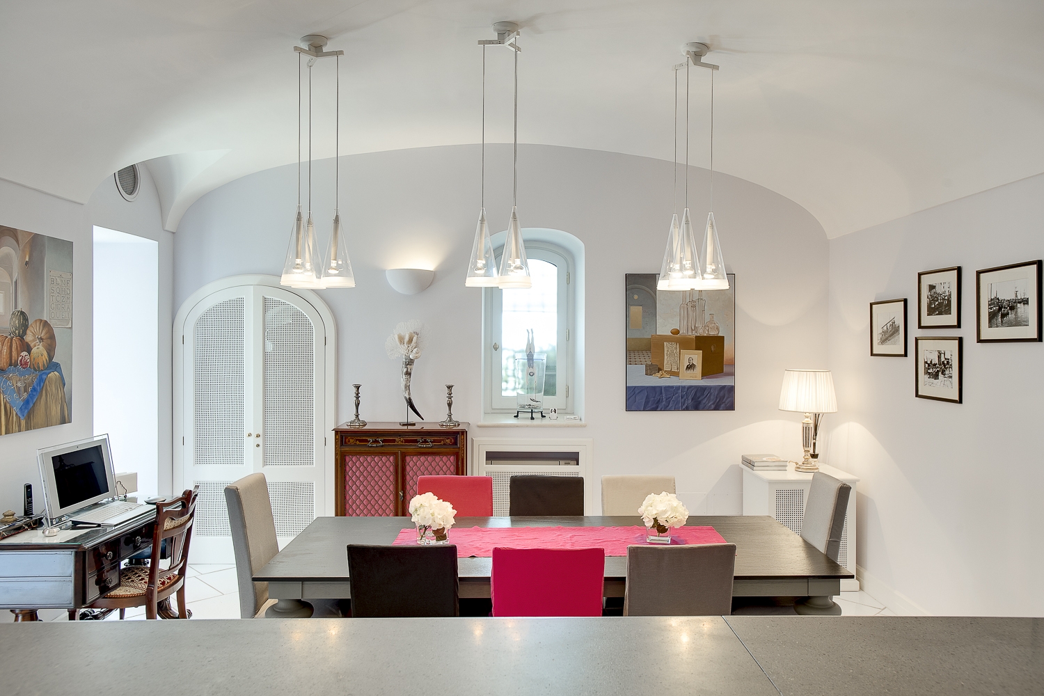 Dining room with table, chairs, hanging lights, pictures, desk and computer at Villa di Praiano on the Amalfi Coast in Italy