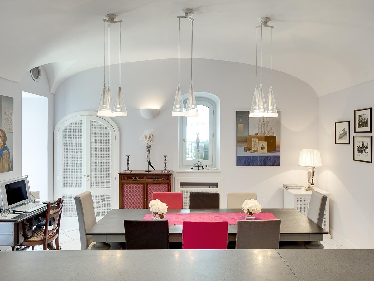 Dining room with table, chairs, hanging lights, pictures, desk and computer at Villa di Praiano on the Amalfi Coast in Italy