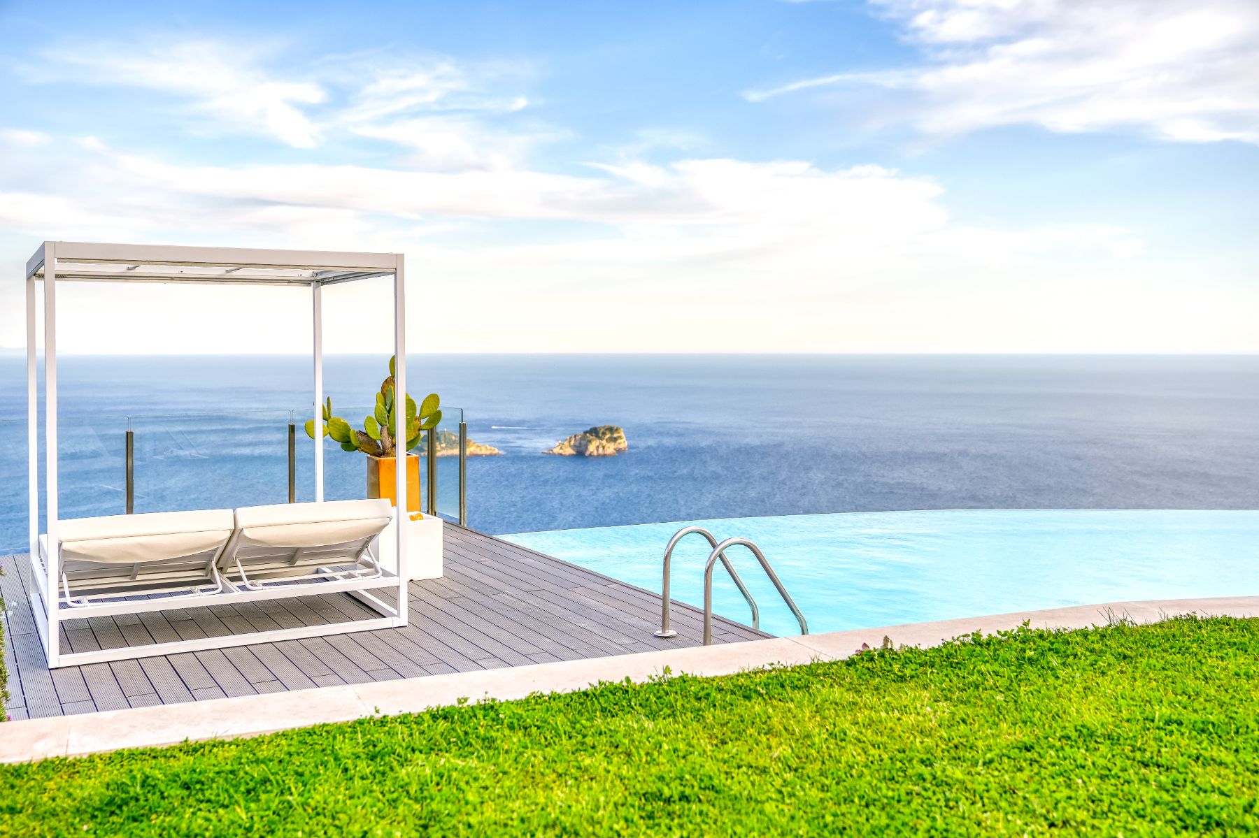 View of the pool and poolside cabana bed with view of the sea at Villa Li Galli in Amalfi