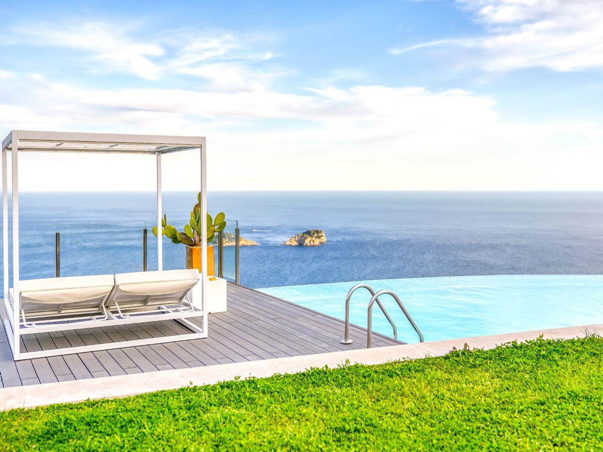 View of the pool and poolside cabana bed with view of the sea at Villa Li Galli in Amalfi