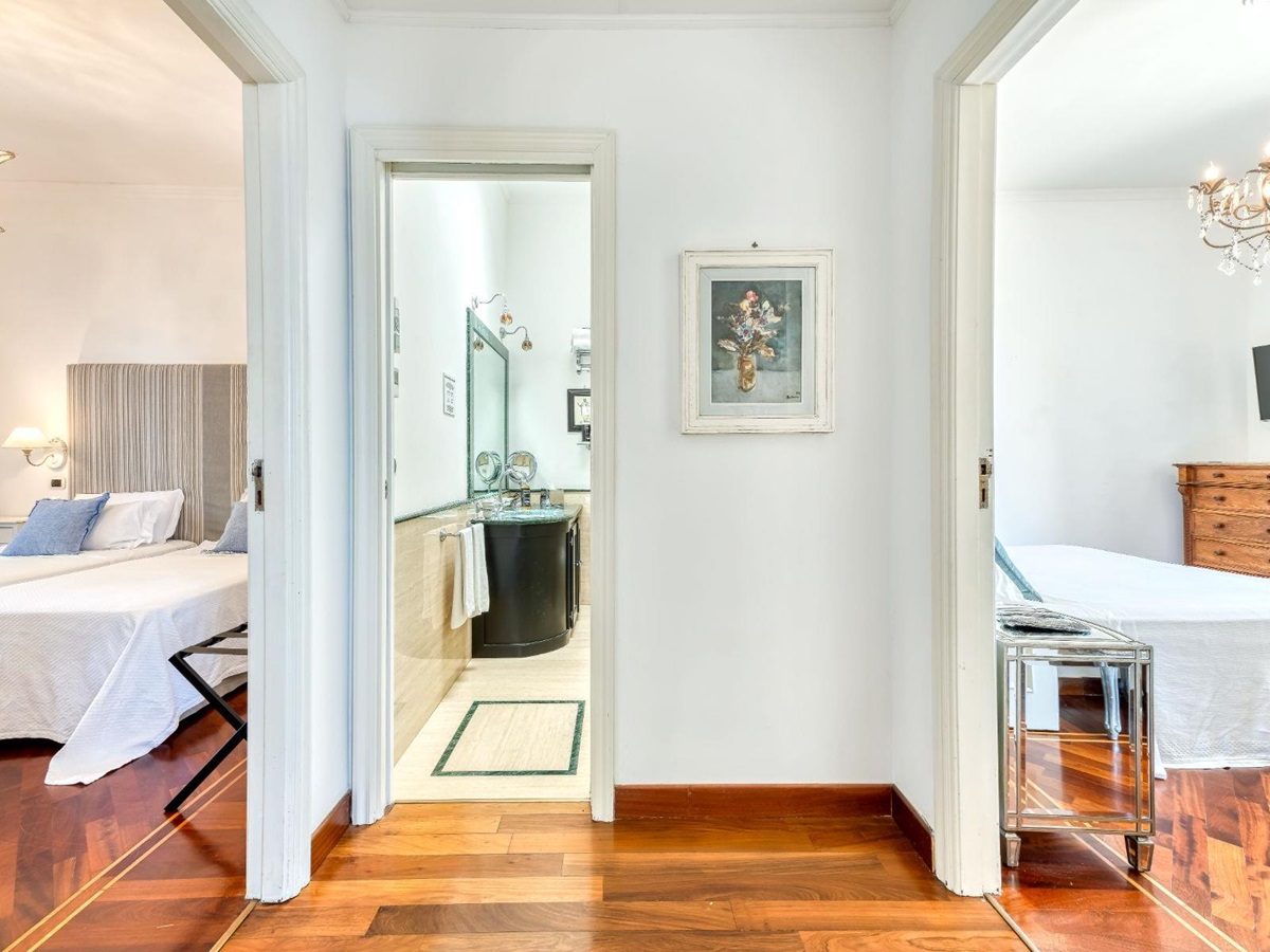 Hallway area with view of the bathroom in the middle and a bedroom either side at Villa Li Galli in Amalfi