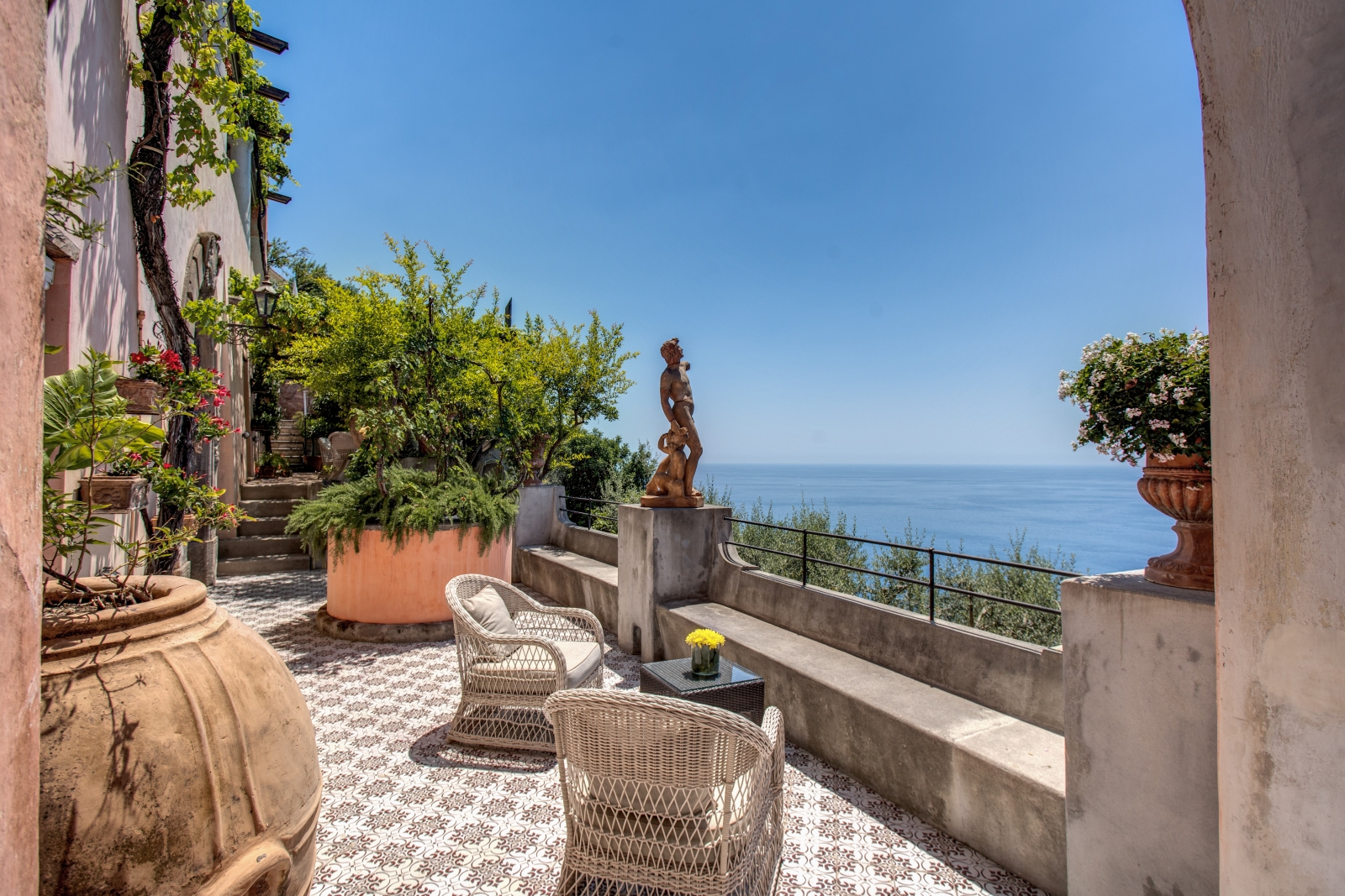 Tiled balcony with two seats and bronze statue of a woman