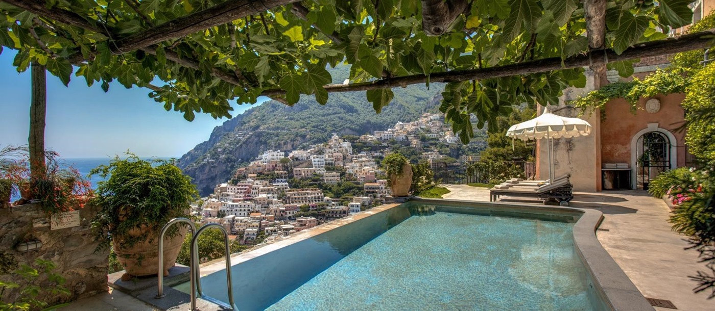 Pool with shaded seating and view towards Amalfi