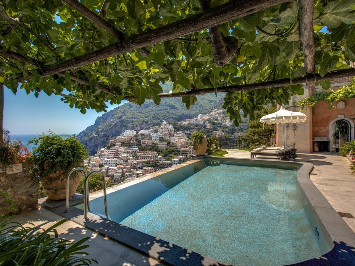 Pool with shaded seating and view towards Amalfi