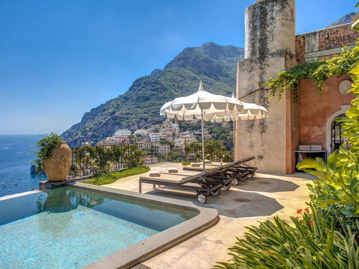 Sun loungers and umbrella on terrace with view in the background