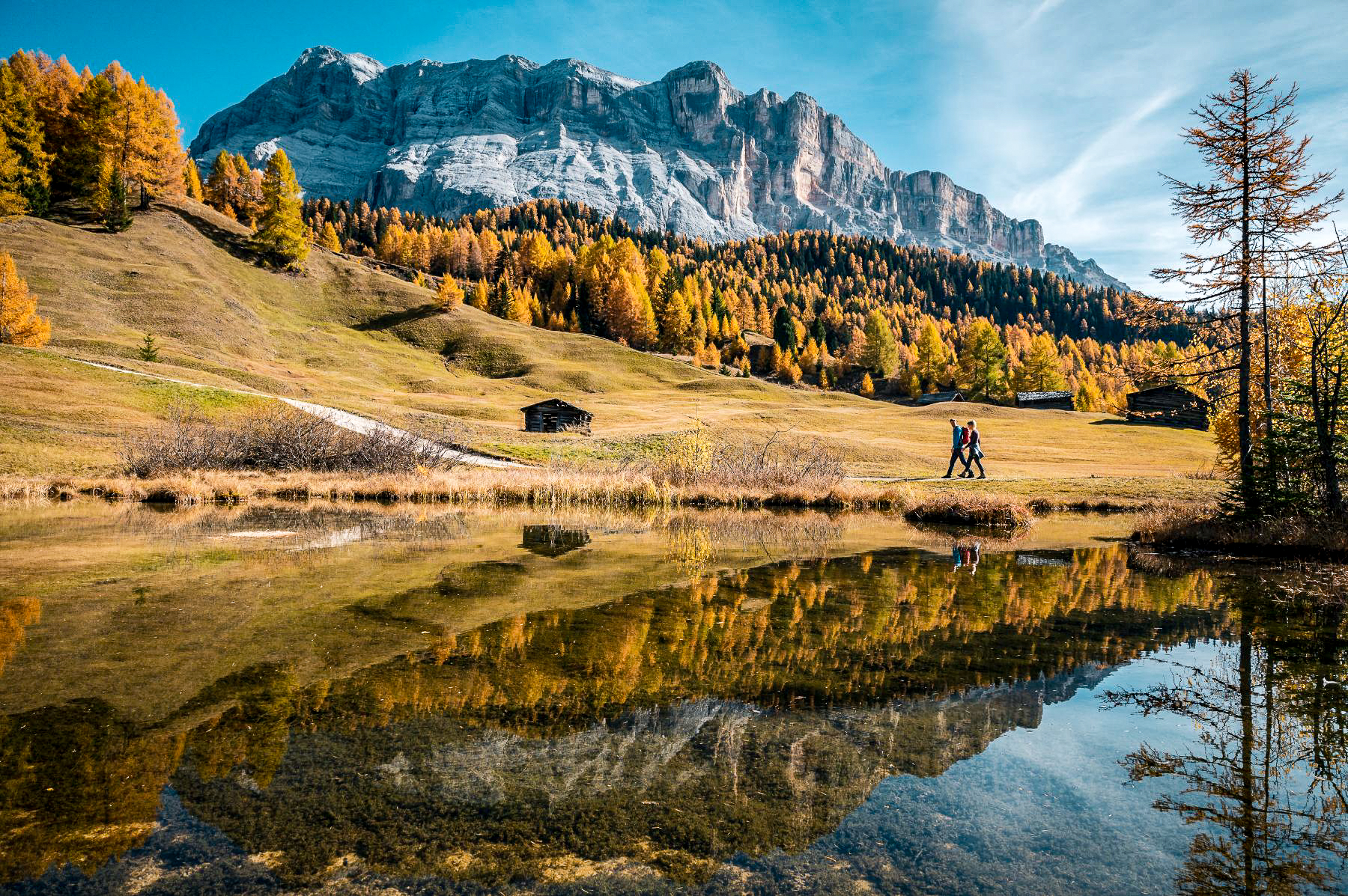 Trekking along a lake in the Dolomites during autumn