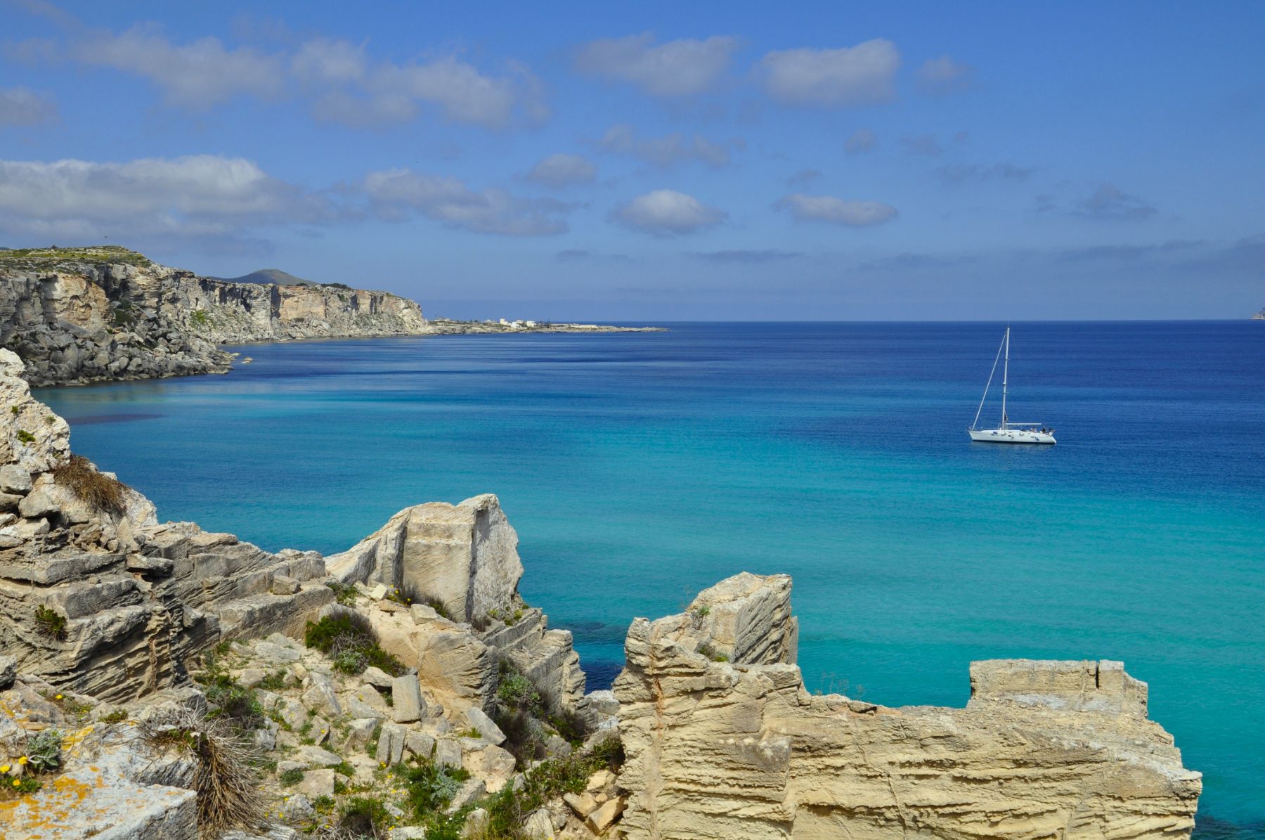 A yacht sailing along the Favignana coastline in Sicily