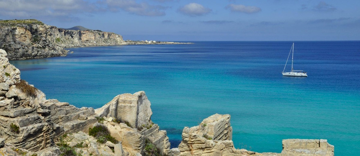 A yacht sailing along the Favignana coastline in Sicily