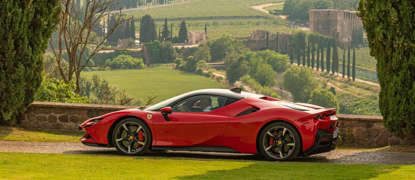 A red Ferrari parked at a viewpoint of Tuscany landscapes in Italy
