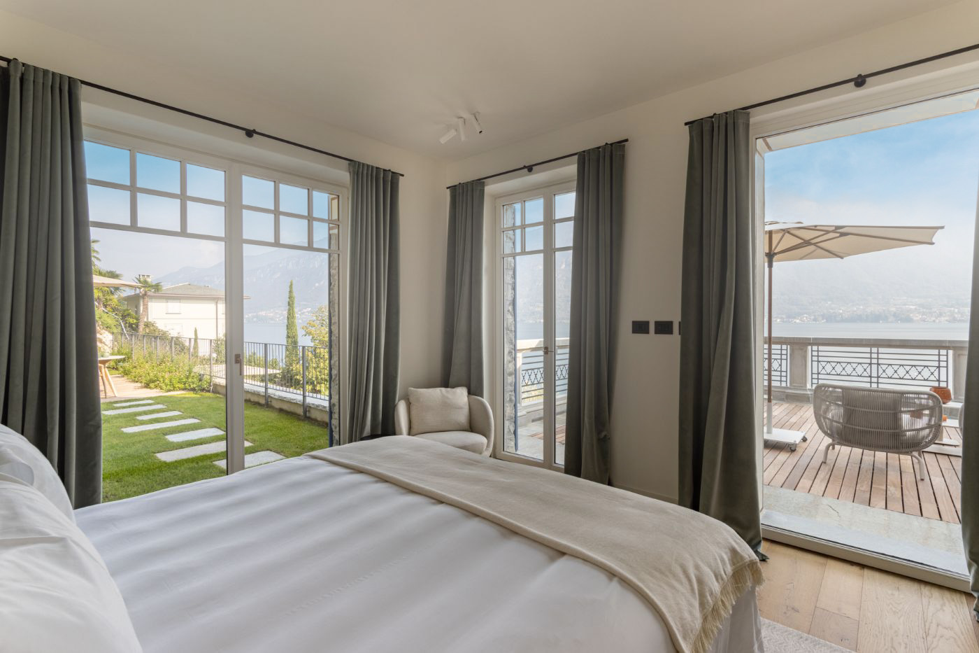 Guest bedroom with private terrace and lake views at vacation rental Breakwater Bellagio on Lake Como