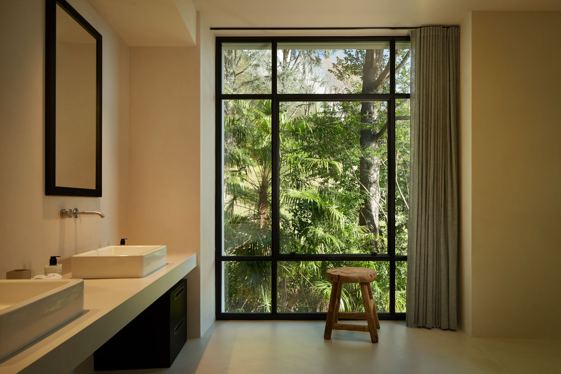 Bathroom at Breakwater Griante in Lake Como with view of a large window with a tree outside and view of basins