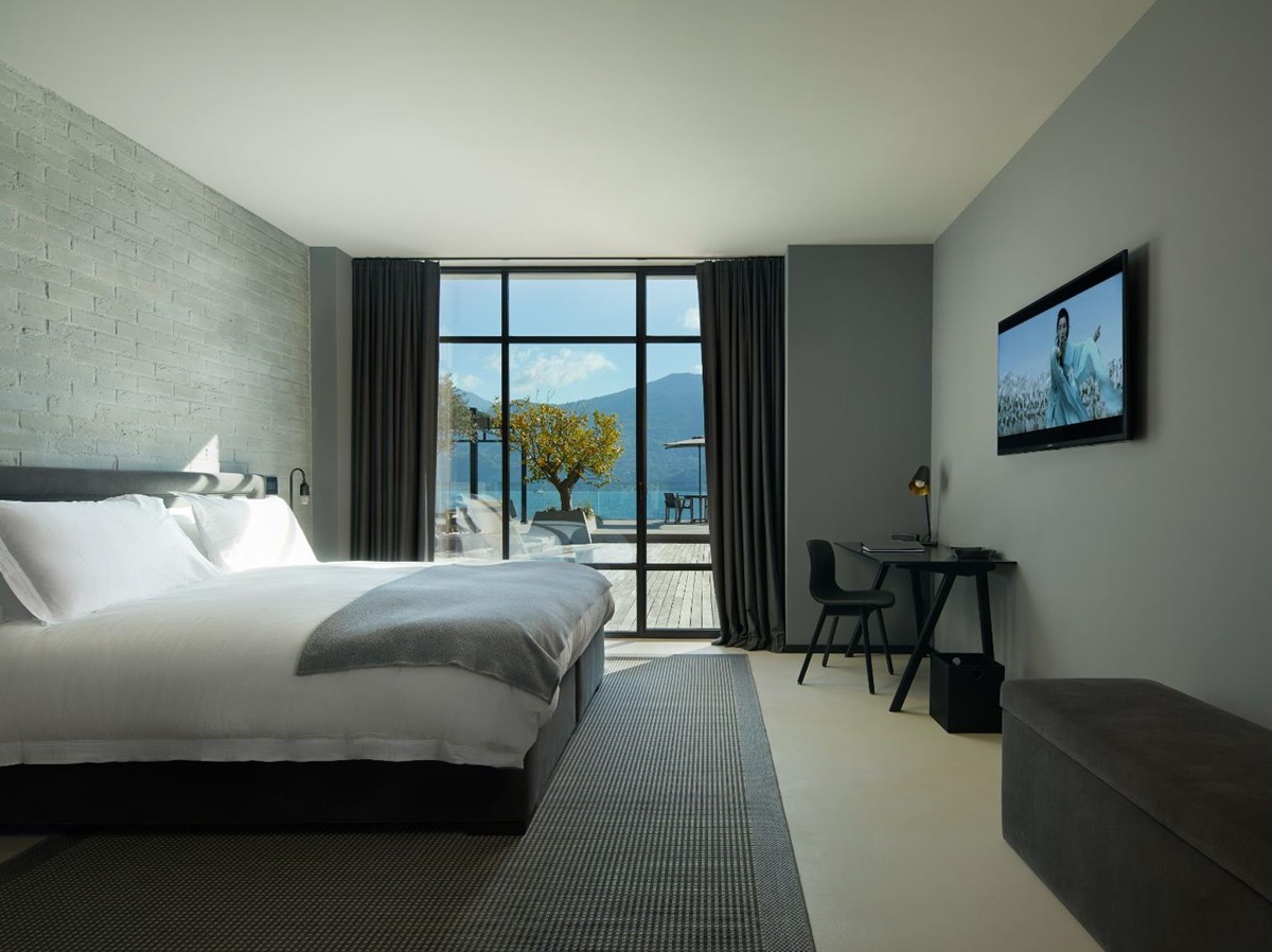 Bedroom in Breakwater Griante in Lake Como with a small black desk and chair and a large open window
