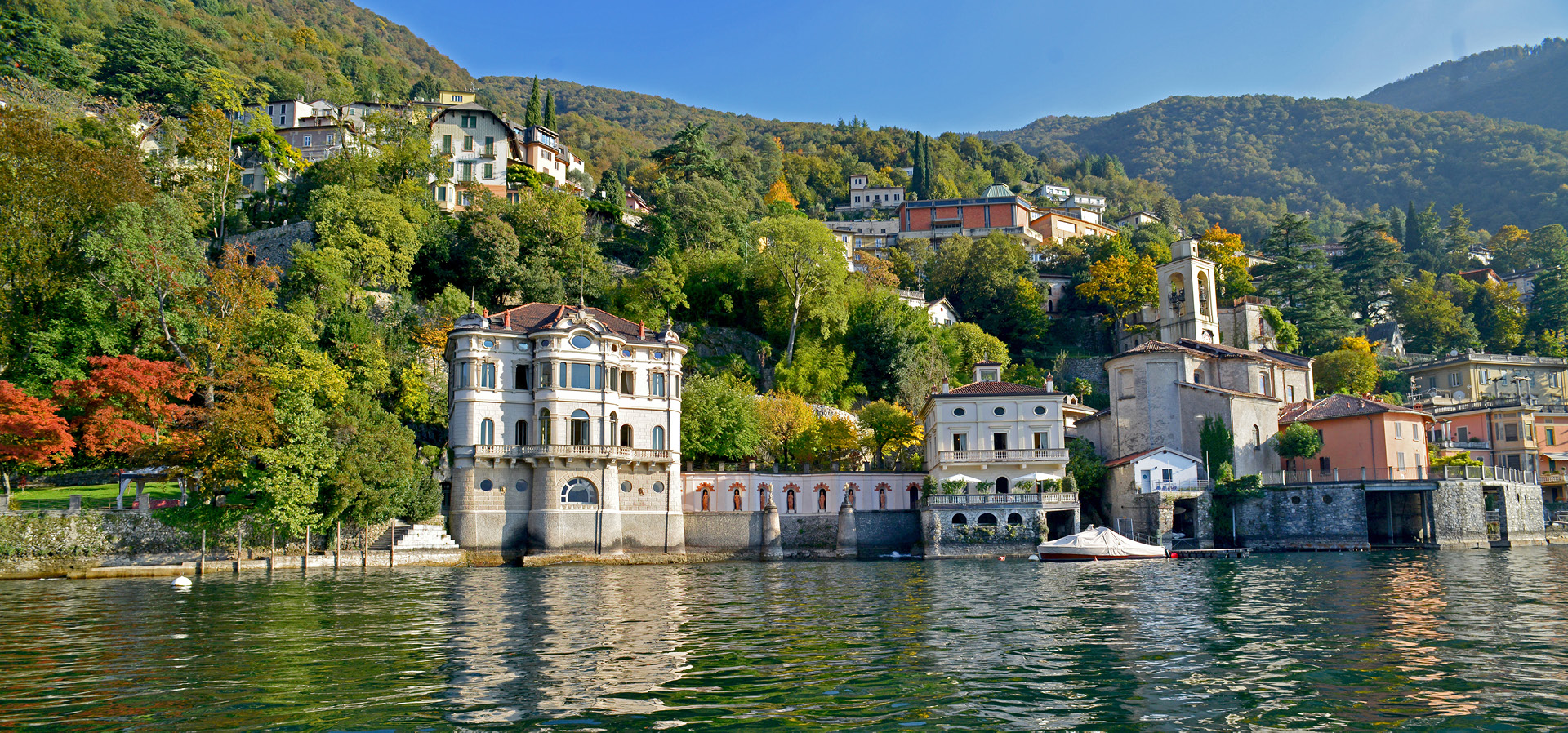 View of villa and mountains from lake at Ville del Lago on Lake Como, Italy