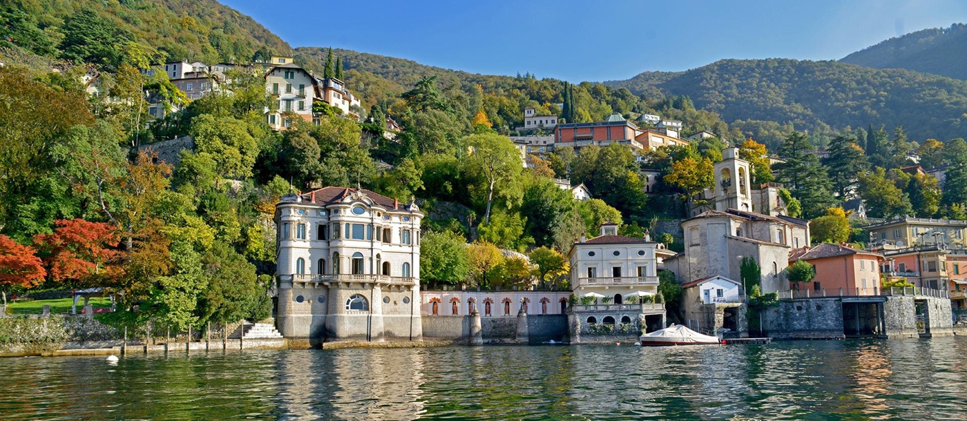 View of villa and mountains from lake at Ville del Lago on Lake Como, Italy