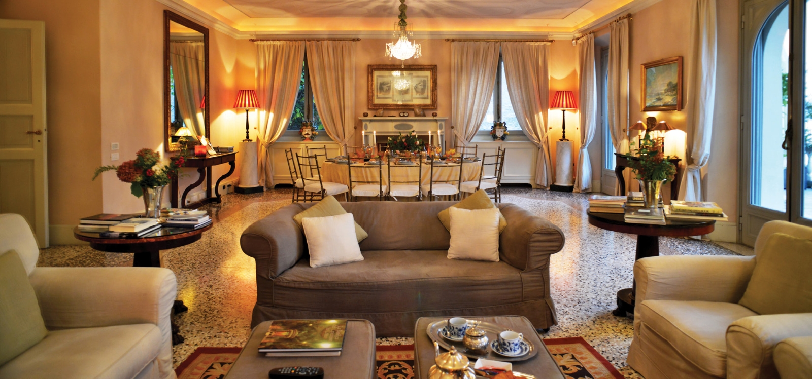 Living room with sofas, dining area, chandelier and balcony access at at Ville del Lago on Lake Como, Italy