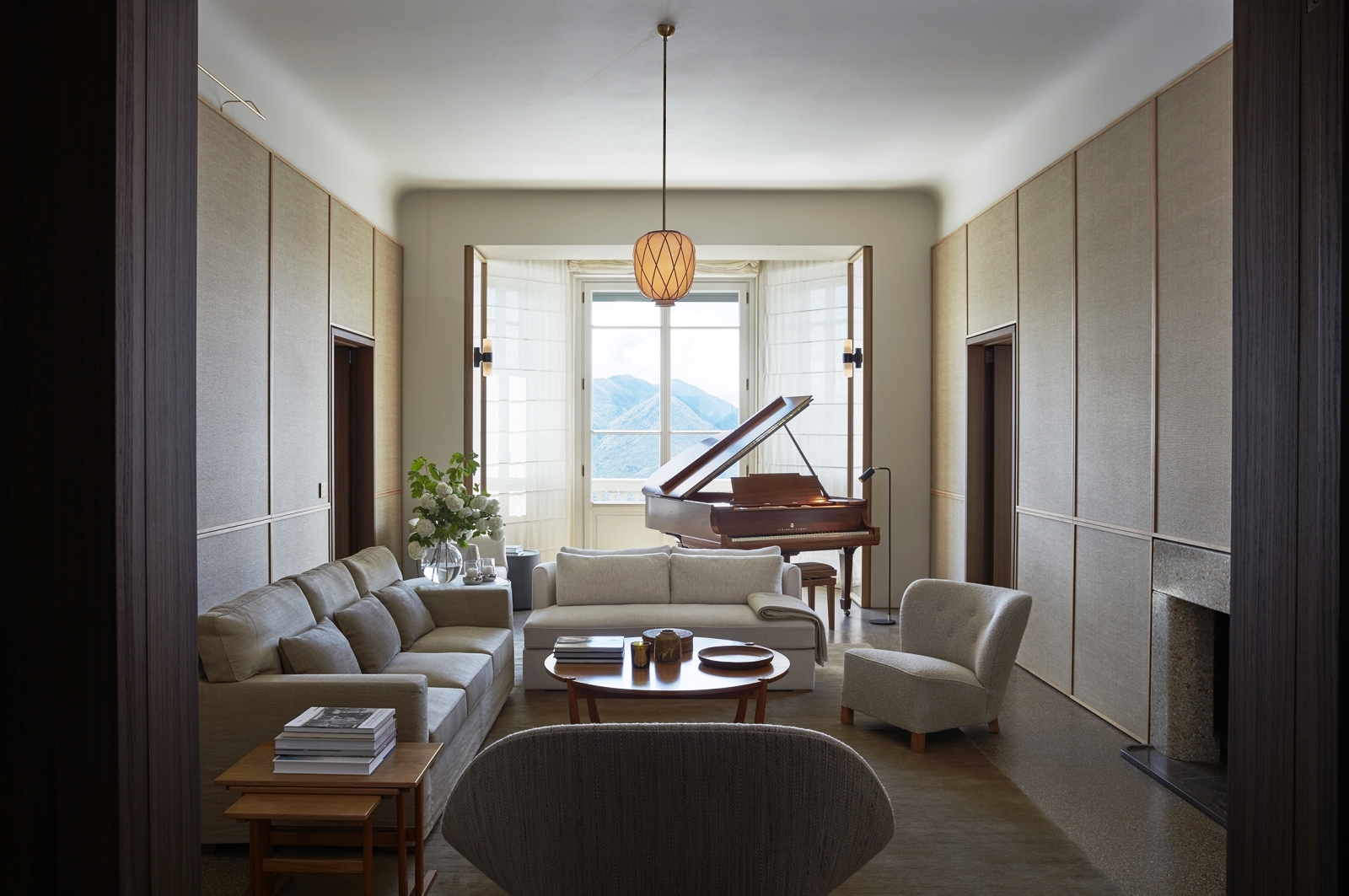 Salon with piano, sofas, armchairs, tables, light & window with mountain view at Villa della Vetta on Lake Como in Italy