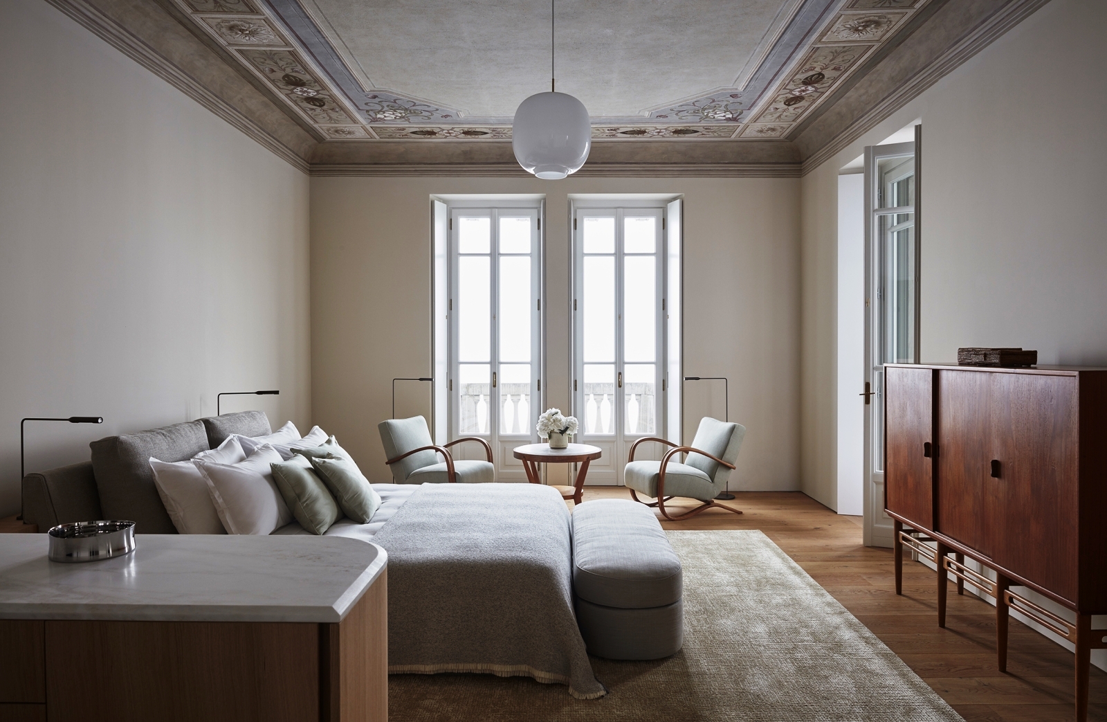 Master suite with worktop, double bed, chairs, table, cabinet and french doors at Villa della Vetta on Lake Como in Italy