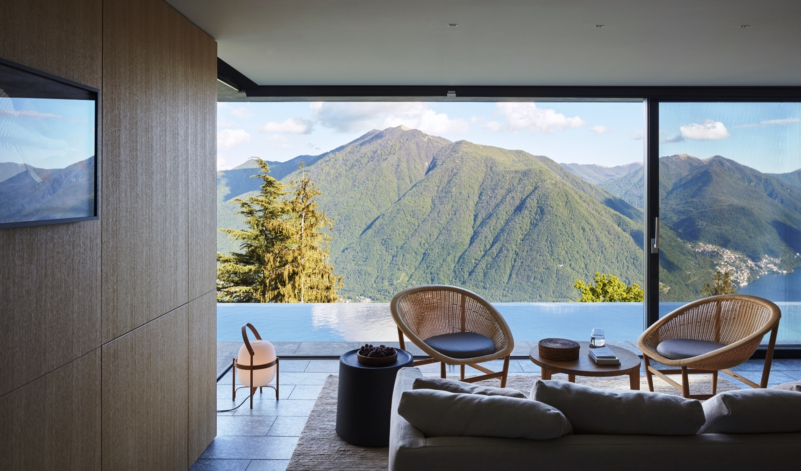 Pool pavillion with sofa, two chairs, two coffee tables and view of mountains at Villa della Vetta on Lake Como in Italy