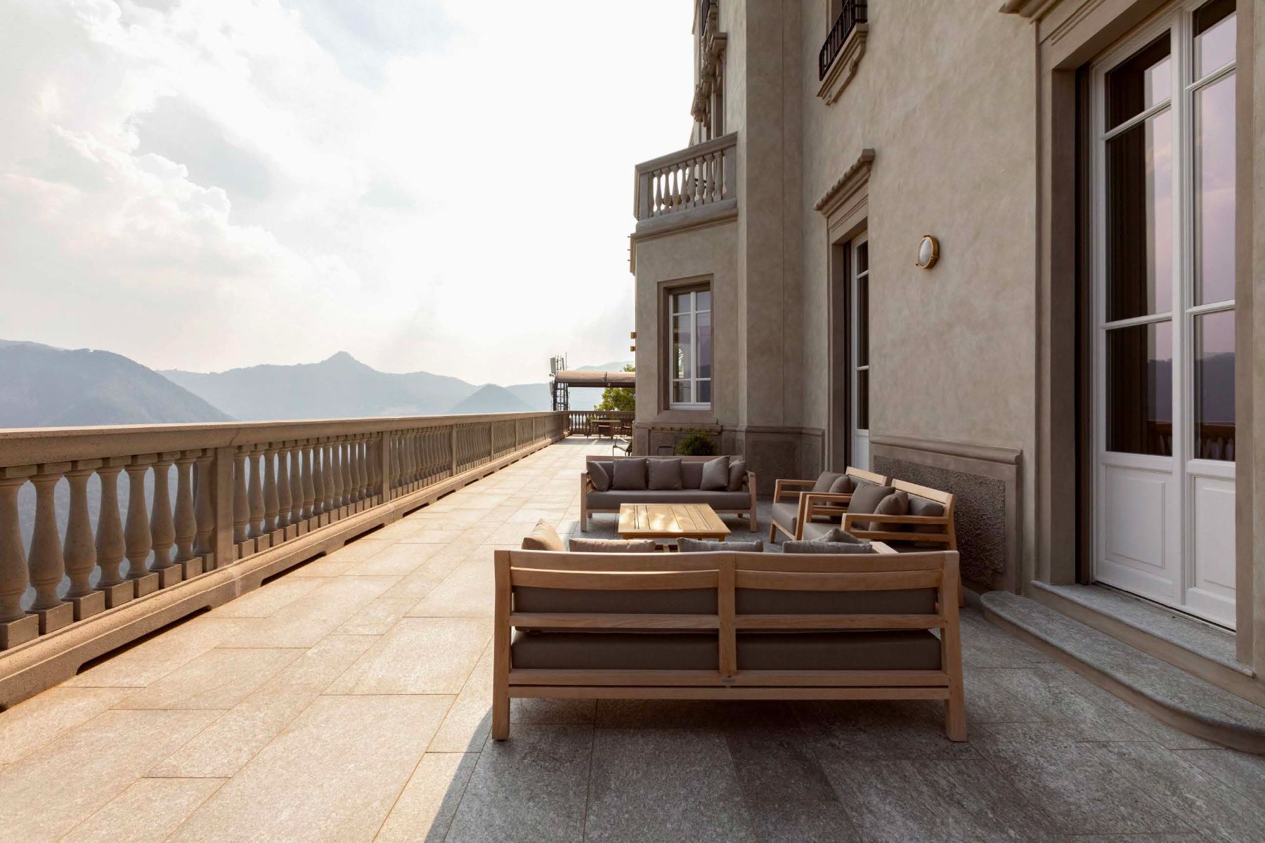 Outdoor terrace area with sofas overlooking Lake Como from Villa Della Vetta
