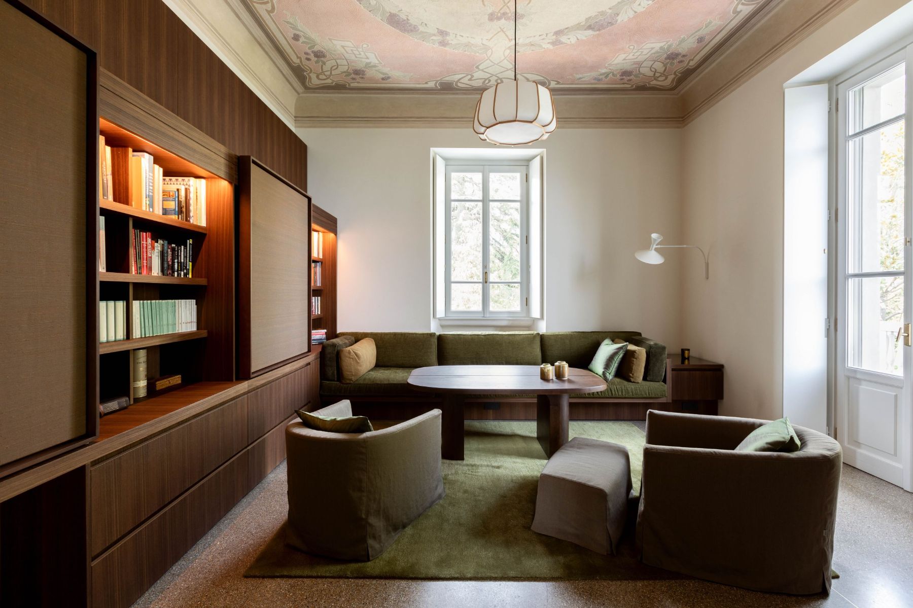 Sitting room with wooden bookshelf and sofa area at Villa Della Vetta in Lake Como