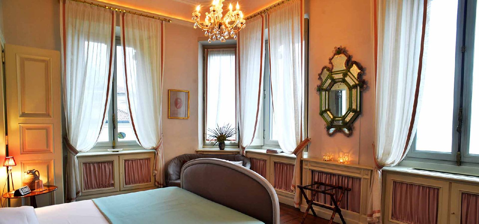 Bedroom with double bed and chandelier at Villa Maria Taglioni on the Italian Lakes