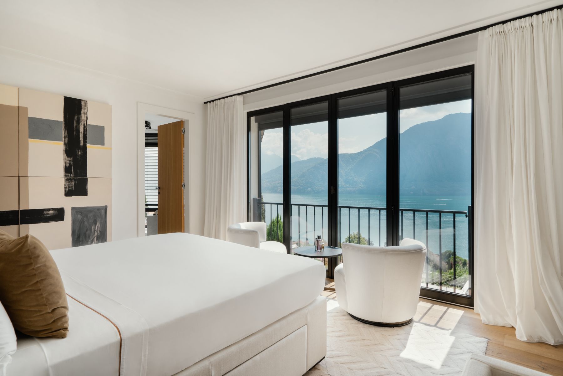 Double bedroom with views over Lake Como from French windows at the foot of the bed at vacation rental Villa Pola in the Italian Lakes, Italy