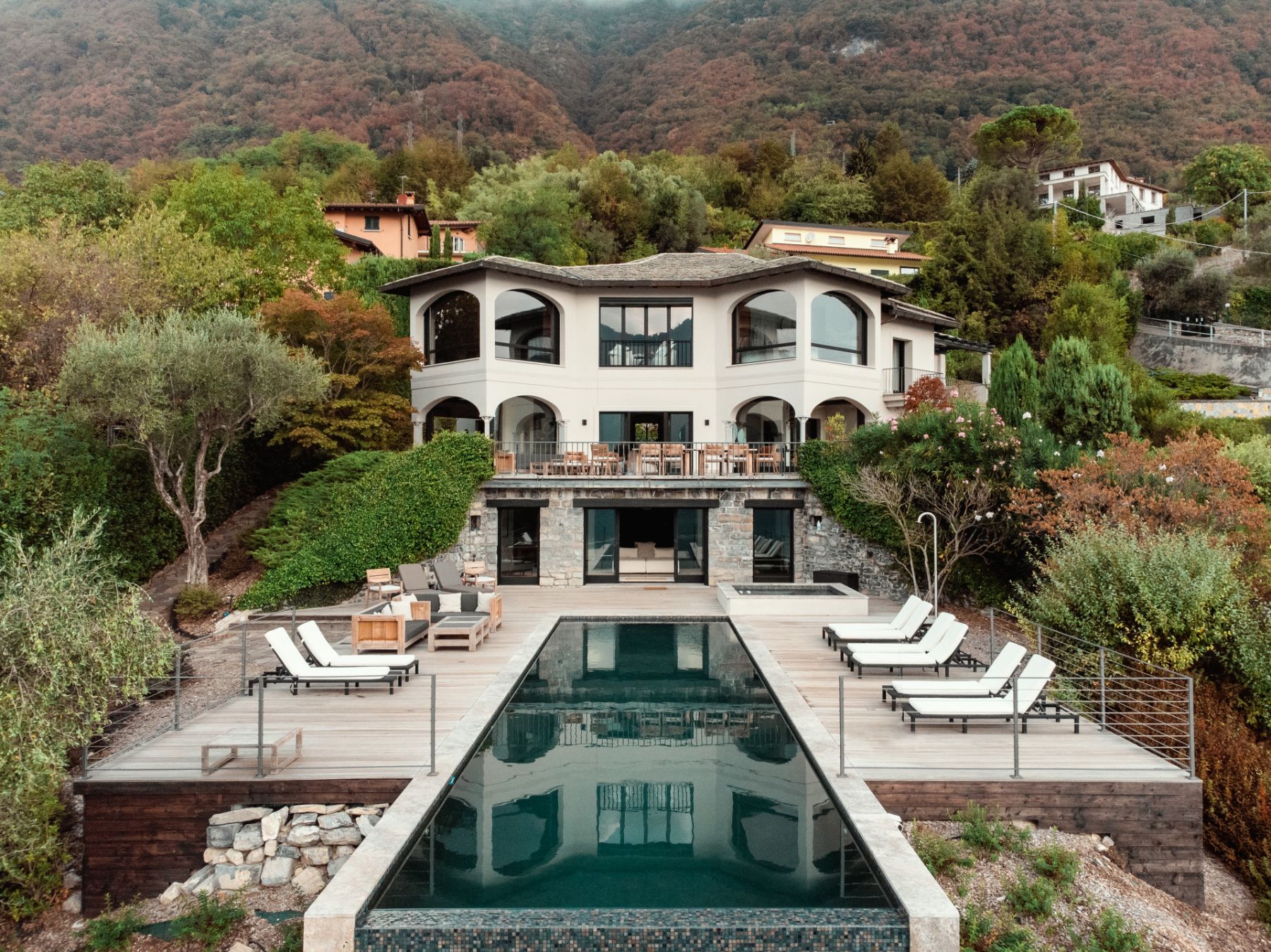 Attactive facade of private vacation rental Villa Pola, with infinity pool and loungers in the foreground, on Lake Como in the Italian Lakes, Italy