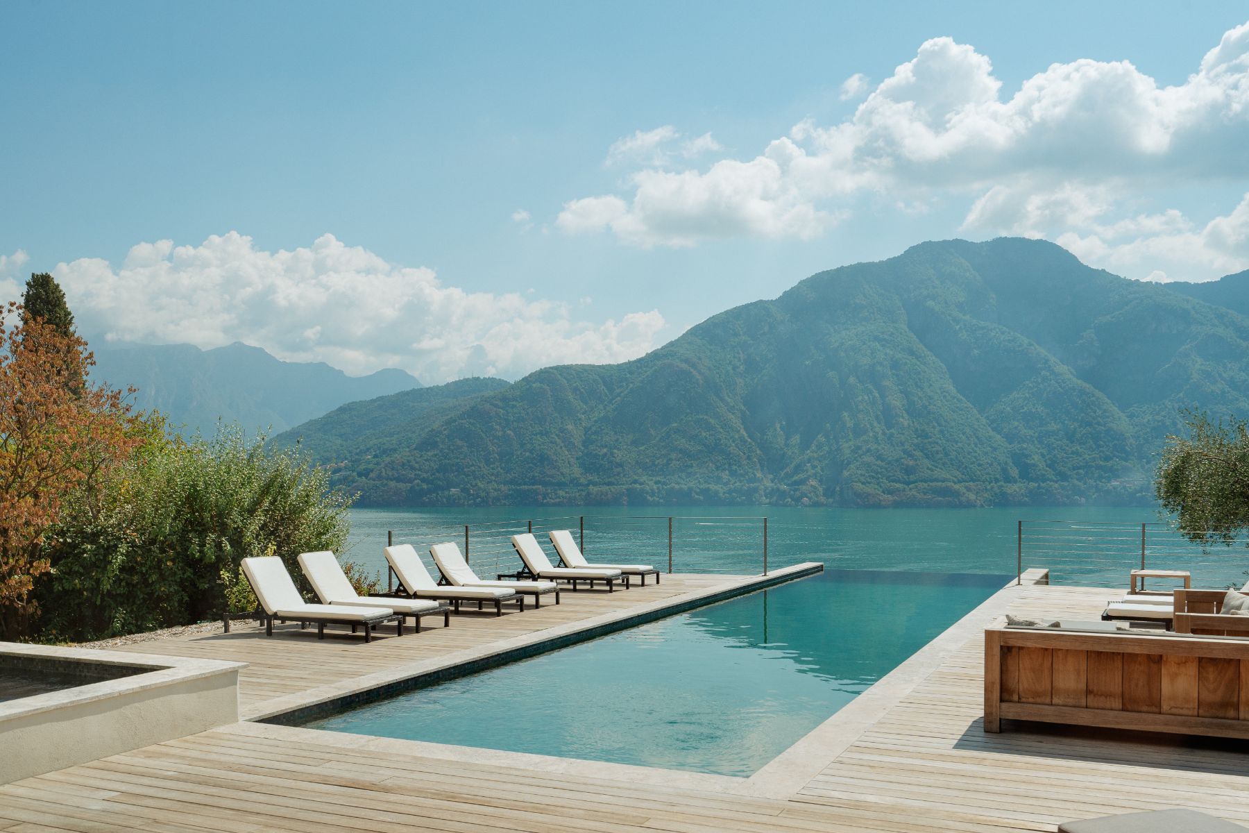 Infinity pool and loungers with beautiful views of Lake Como at luxury villa rental, Villa Pola in the Italian Lakes, Italy