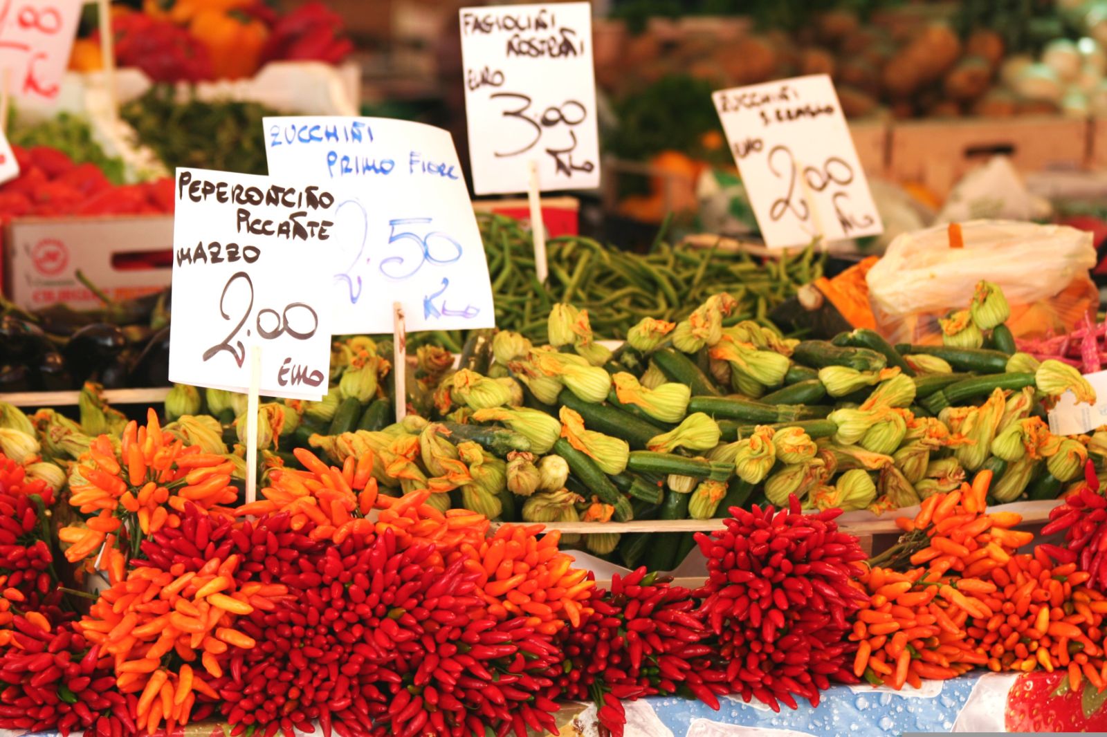 Peppers and courgettes on sale at a colourful food market in Italy