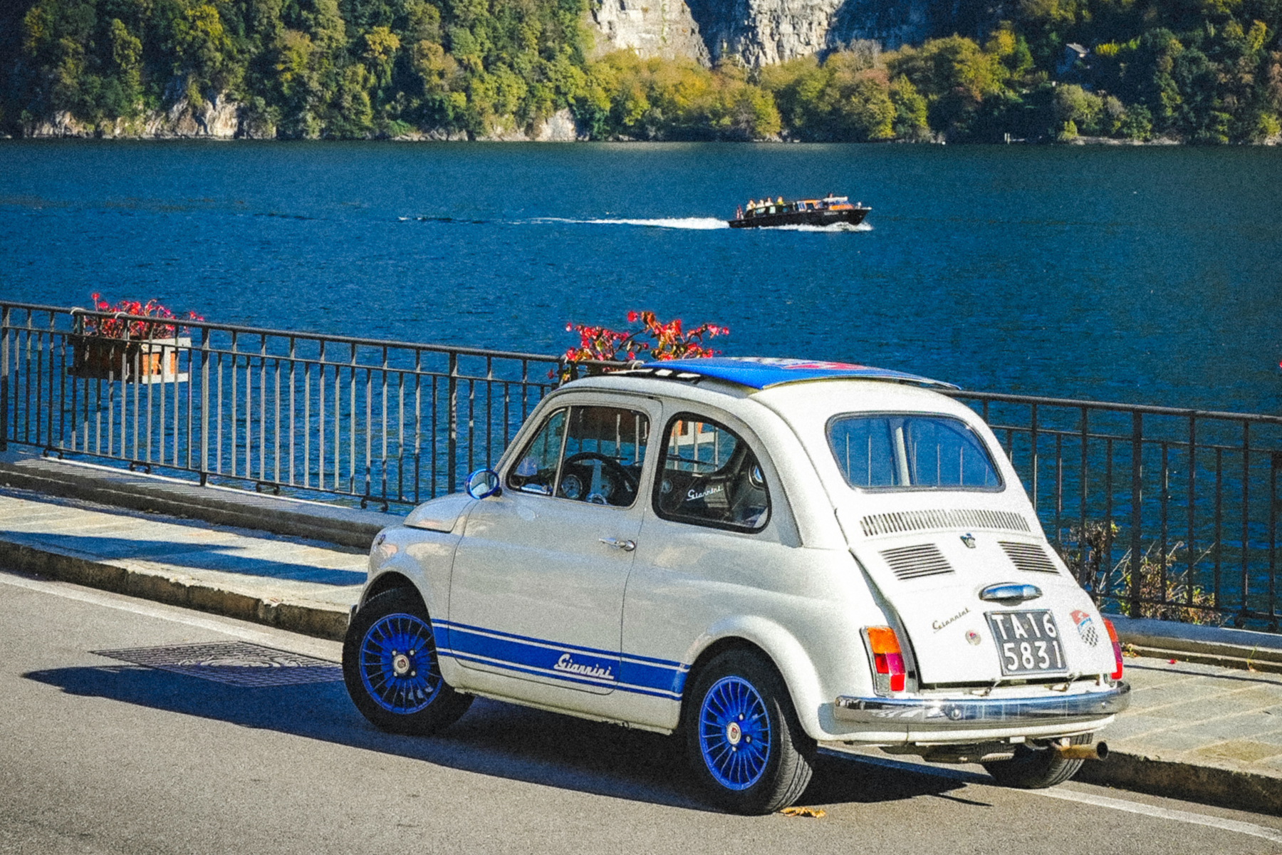 A fiat 500 parked along the banks of Lake Como