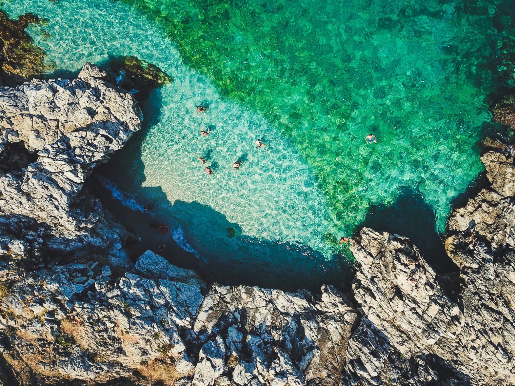 Aerial view of people swimming in the Lo Zingano cove in Sicily