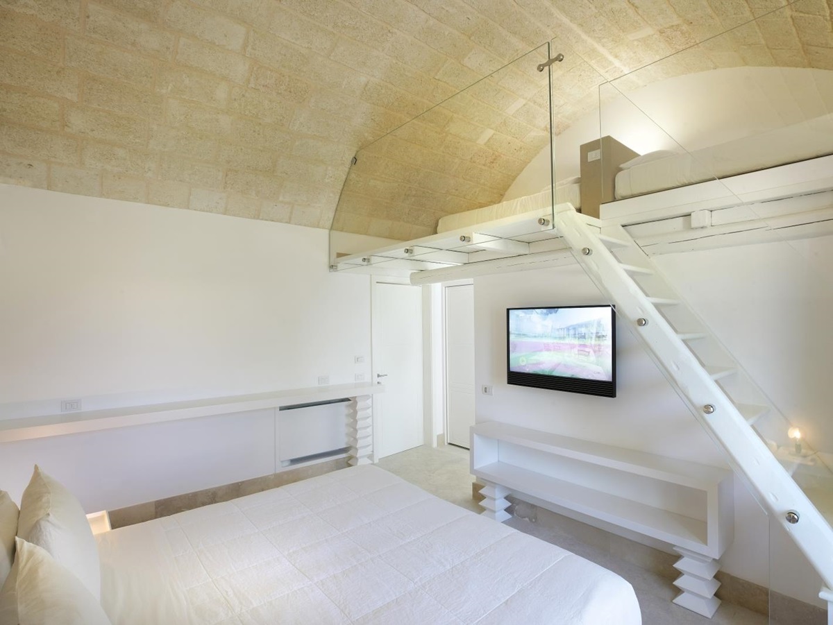 Family bedroom with double bed, TV and mezzanine floor at Masseria dei Papi in Puglia, Italy
