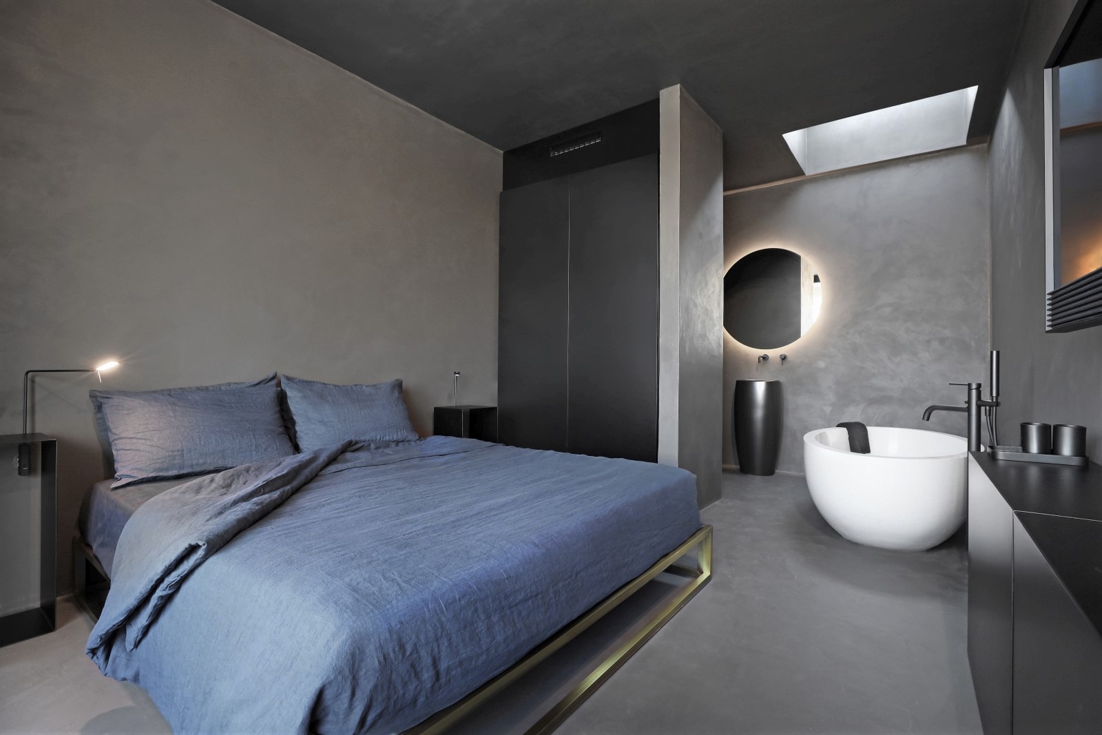 Bedroom with double bed, bedside tables, lamps, bathtub and sink at Masseria dei Papi in Puglia, Italy