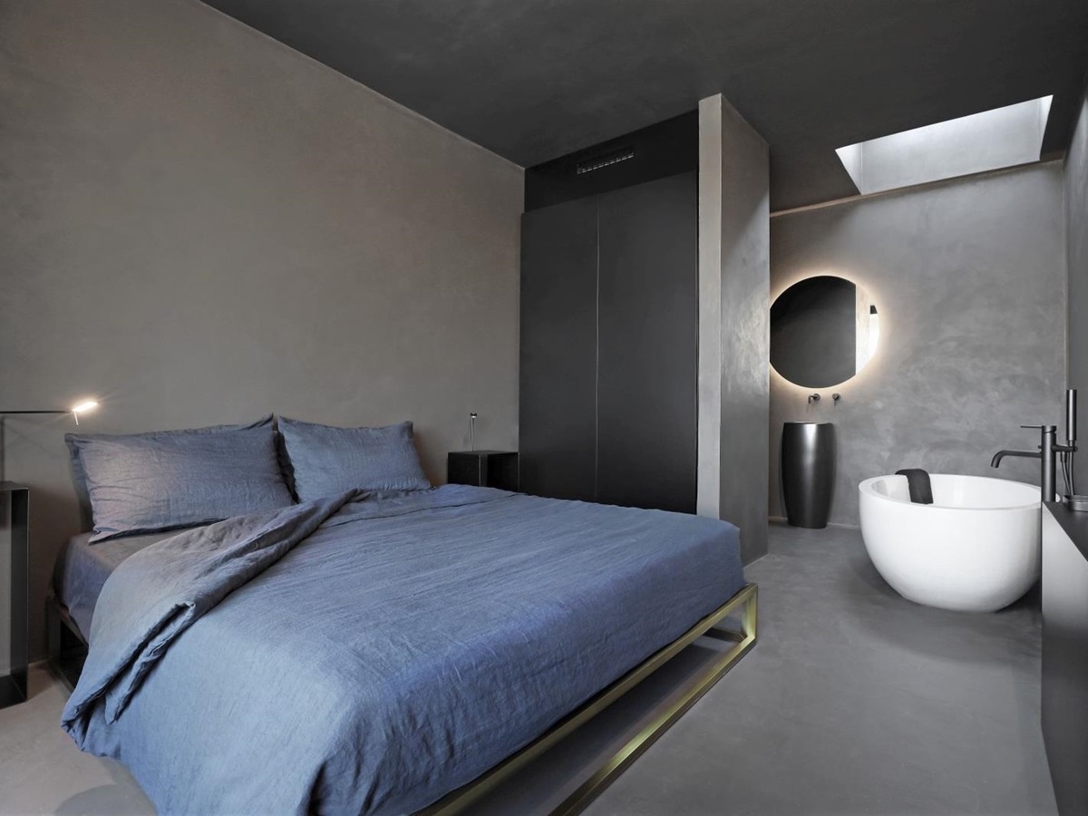 Bedroom with double bed, bedside tables, lamps, bathtub and sink at Masseria dei Papi in Puglia, Italy