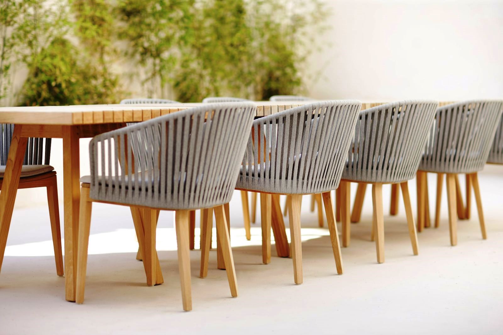 Wooden dining table with 8 beige slatted charis at villa masseria dei papi in Puglia, Italy